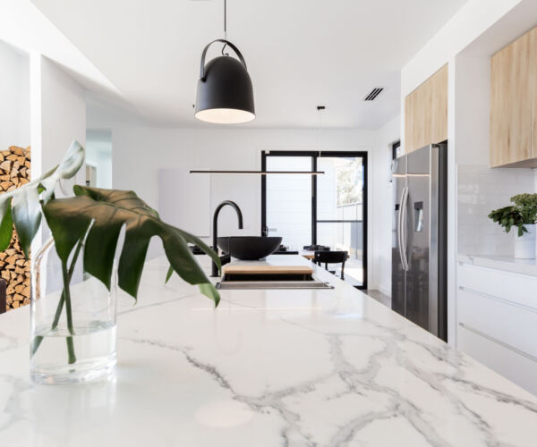Kitchen marble bench close up with black hanging pendant and vas